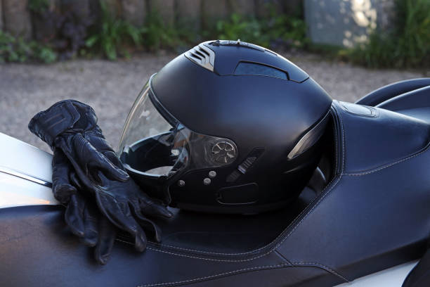 Black motorcycle helmet and gloves placed on a bike seat