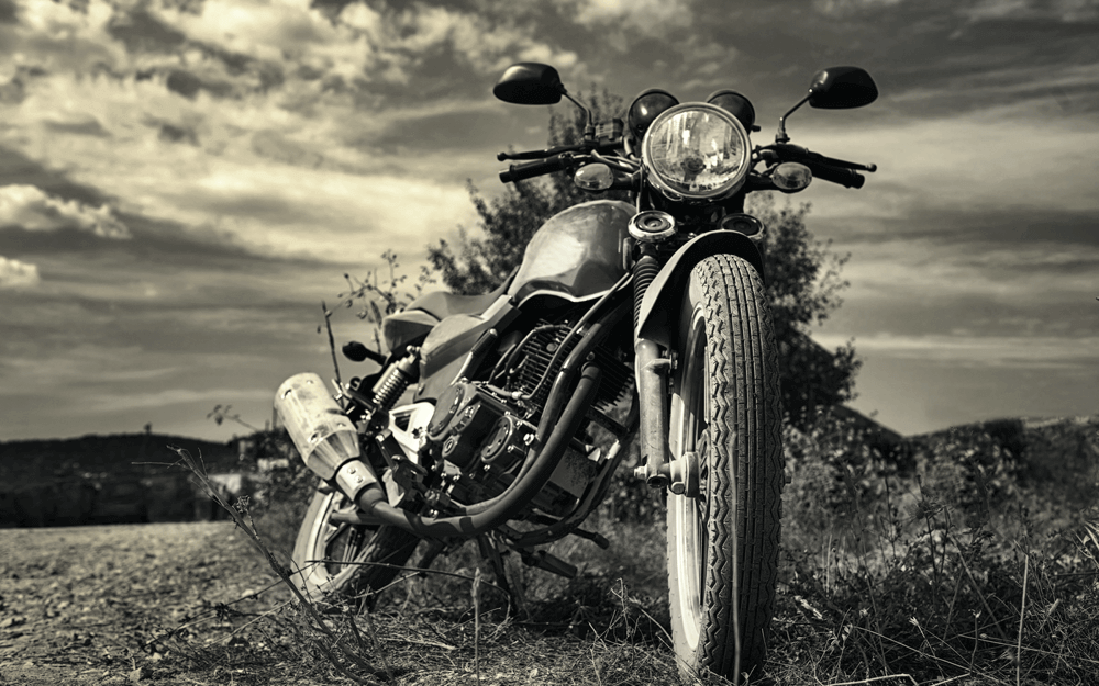 A vintage motorcycle parked on a dusty trail in the countryside
